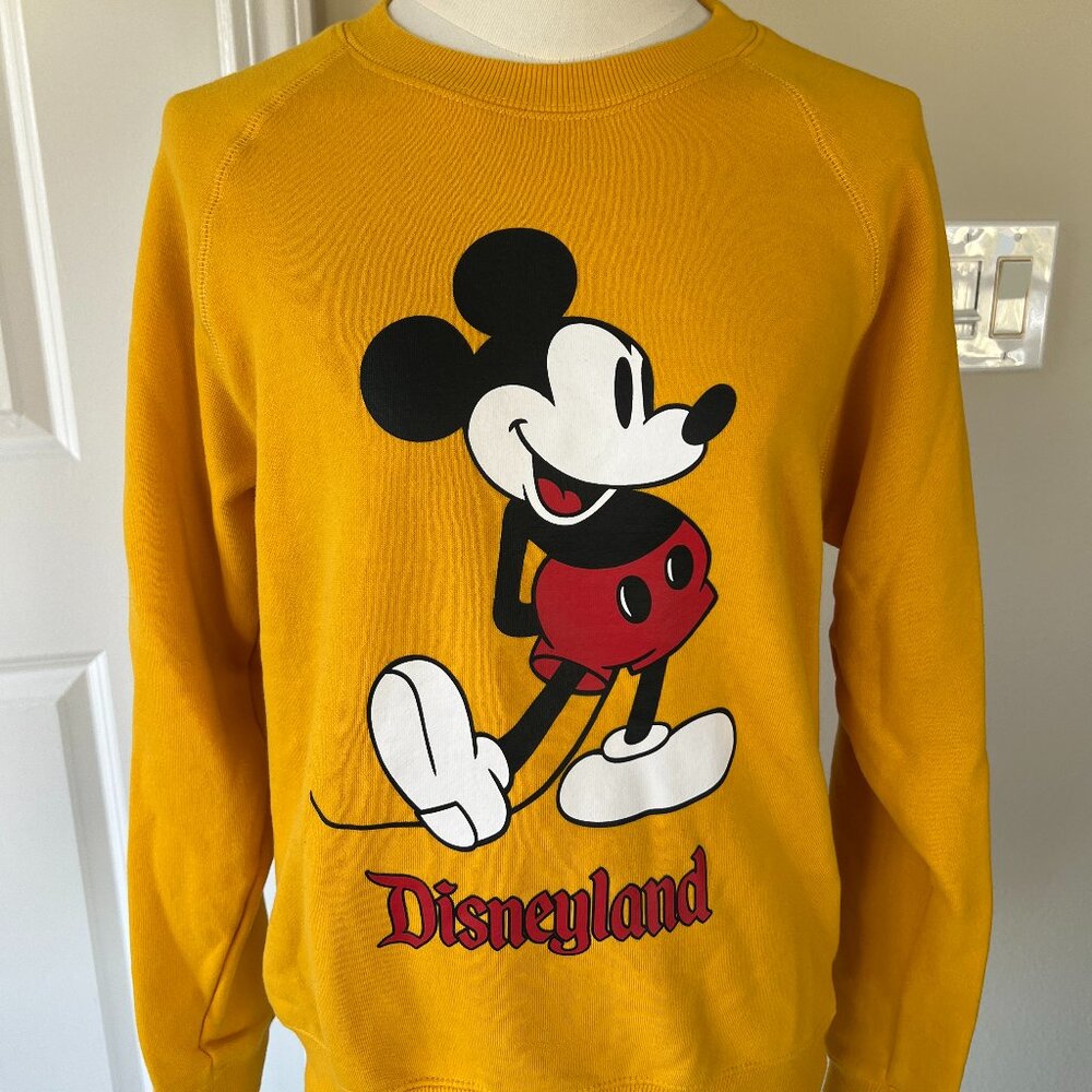 Disney unisex size small golden yellow sweater NWOT in excellent condition.